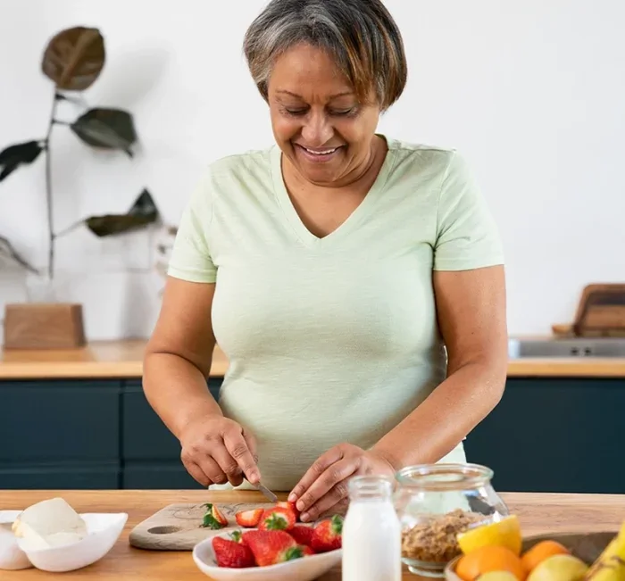 Woman preparing fresh strawberries and whole foods in her kitchen